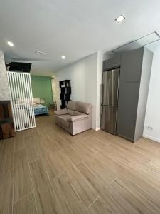 a living room with a couch and a refrigerator at Apartamentos Aguacate in Madrid