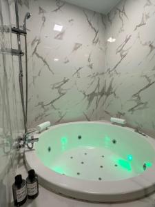 a bath tub in a bathroom with marble walls at Apartamentos Aguacate in Madrid