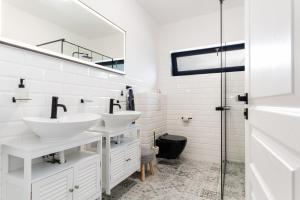 a white bathroom with two sinks and a shower at Malina Penati golf in Šajdíkove Humence