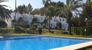 una gran casa blanca con piscina frente a ella en Bungalow Los Almendros, en Pedreguer