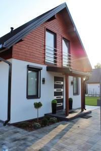 una pequeña casa blanca con techo rojo en Domek Hampton Lubniewice jezioro, blisko spa, en Lubniewice