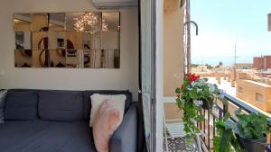 sala de estar con sofá y balcón en Playa El Palo Apartment by SharingCo, en Málaga