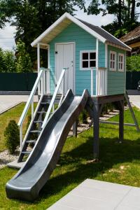 a slide in front of a play house at Kurka Chata in Nowy Targ