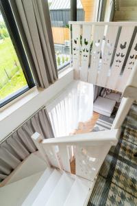 eine weiße Treppe in einem Zimmer mit Fenster in der Unterkunft Kurka Chata in Nowy Targ