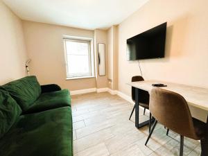 a living room with a green couch and a table at Seaview Central Brighton One Bedroom Flat in Brighton & Hove