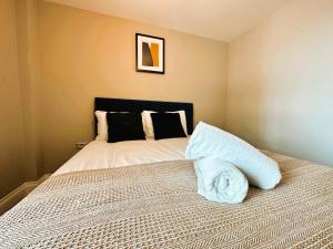 a bedroom with a bed with a black headboard at Seaview Central Brighton One Bedroom Flat in Brighton & Hove