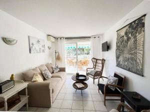 a living room with a couch and a table at Bel appartement 3 pièces climatisé 400m des plages in Cavalaire-sur-Mer