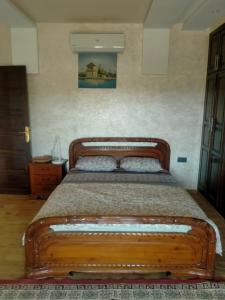 een bed in een slaapkamer met een houten frame bij Villa khaddouj Marrakech in Marrakesh