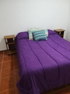 Una cama morada con dos almohadas encima. en Monoambiente La Boca en Buenos Aires