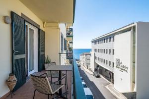 a balcony with chairs and a table and a view of the ocean at Recanto da Princesa by Madeira Sun Travel in Funchal