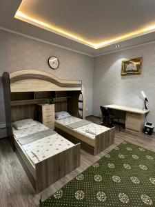 een kamer met 2 bedden, een tafel en een bureau bij Ultra Hostel in Doesjanbe