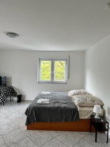 Schlafzimmer mit einem Bett und einem Fenster in der Unterkunft Pension Seckbach in Frankfurt am Main