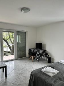 Schlafzimmer mit einem Bett, einem Tisch und einem Fenster in der Unterkunft Pension Seckbach in Frankfurt am Main