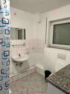 a bathroom with a sink and a toilet and a tub at Pension Seckbach in Frankfurt/Main