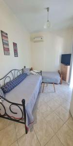 a bedroom with a bed and a couch and a tv at Retas apartment in Kremasti
