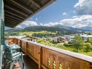 a balcony with a table and chairs and mountains at Ferienwohnungen Haus Schwaiger in Fieberbrunn