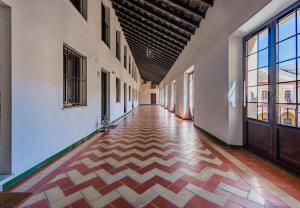 een lege hal van een gebouw met een tegelvloer en ramen bij Apartamento Historico Garaje y WIFI in Sanlúcar de Barrameda