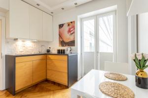 een keuken met witte kasten en een witte tafel bij GA- Luxury Apartment-Top Location&Żurawia in Warschau