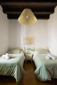 een kamer met 2 bedden en een kroonluchter bij Apartamento Historico Garaje y WIFI in Sanlúcar de Barrameda