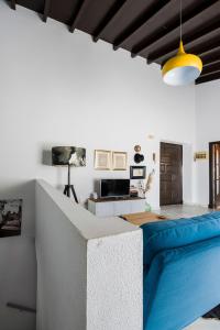 een woonkamer met een blauwe bank en een tv bij Apartamento Historico Garaje y WIFI in Sanlúcar de Barrameda