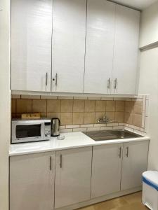 La cuisine est équipée de placards blancs, d'un évier et d'un four micro-ondes. dans l'établissement Shades of Zante 1, à Katastárion