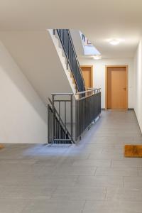 pusty korytarz ze schodami w budynku w obiekcie Los Lorentes Residences Bulle - Hine Adon w mieście Bulle