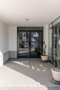 una entrada a un edificio de oficinas con puertas de cristal en Los Lorentes Residences Bulle - Hine Adon en Bulle