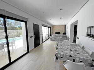 een eetkamer met een tafel en stoelen en een zwembad bij BAMBÚ SUP · Casa rural en Vejer con piscina privada in Vejer de la Frontera