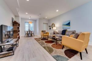 ein Wohnzimmer mit einem Sofa und einem TV in der Unterkunft Luxe Townhouse Flat in Hip Neighborhood, Near Metro in Washington