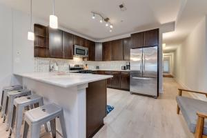 a kitchen with wooden cabinets and a stainless steel refrigerator at Luxe Townhouse Flat in Hip Neighborhood, Near Metro in Washington