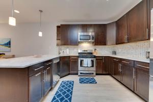 a kitchen with wooden cabinets and a stove top oven at Luxe Townhouse Flat in Hip Neighborhood, Near Metro in Washington