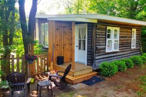 una piccola cabina di legno con veranda e sedie di Le Perché-sur-la-rivière a Joliette Altre 4 foto