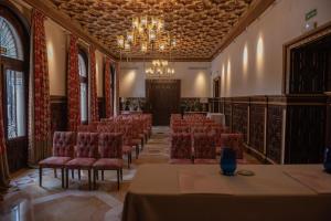 una sala conferenze con sedie e lampadario pendente di Hotel Casa Palacio María Luisa a Jerez de la Frontera