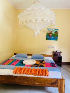 1 dormitorio con 1 cama con dosel blanco en Fig Tree Lodge Camp, en Mto wa Mbu