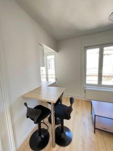 een kamer met een houten tafel en 2 stoelen bij Las Vegas - appartement à Reims in Reims