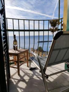a balcony with a chair and a table and the ocean at La Peglina in Genoa