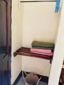 ein Regal in einem Zimmer mit einigen Handtüchern darauf in der Unterkunft Fig Tree Lodge Camp in Mto wa Mbu