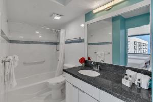 a bathroom with a sink and a toilet and a mirror at Standard Ocean View Condo - 36th Floor, Free parking & Wifi condo in Honolulu