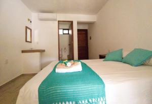 a bedroom with a bed with a green and white blanket at Casa Yoo Bigu Mazunte in Mazunte
