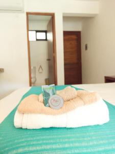 a bed with a towel and a book on it at Casa Yoo Bigu Mazunte in Mazunte