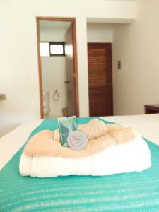 a bed with a towel and a book on it at Casa Yoo Bigu Mazunte in Mazunte