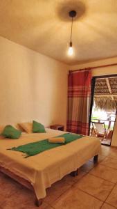 a bedroom with a large bed with green pillows at Casa Yoo Bigu Mazunte in Mazunte