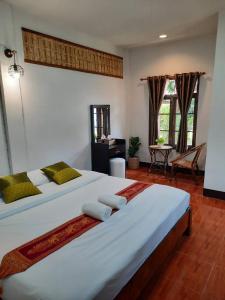 a bedroom with a large white bed with towels on it at Hotel Pailifornia in Pai