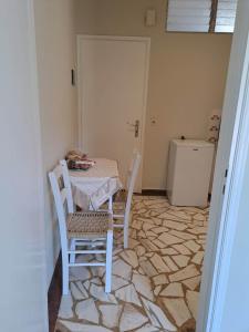 a dining room with a table and chairs on a marble floor at Rois Appartments in Poros