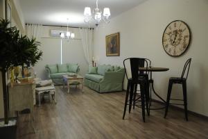 a living room with a couch and a clock on the wall at The Central Suites in Nicosia