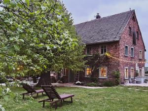 a brick house with two benches in front of it at Dom na Krzewiu in Gryfów Śląski