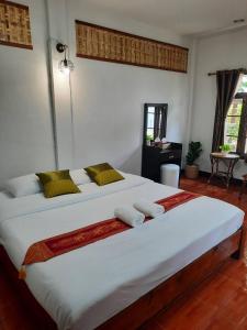 a bedroom with a large white bed with two pillows at Hotel Pailifornia in Pai