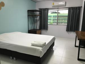 Schlafzimmer mit einem Bett, einem Fenster und einem Schreibtisch in der Unterkunft Nimman Expat Home in Chiang Mai