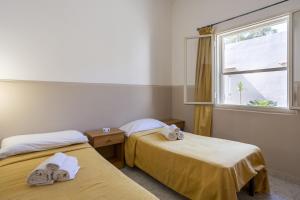 two beds in a room with a window at Oasi lamia - 3 in Mazara del Vallo