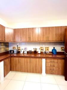 a kitchen with wooden cabinets and a counter top at Spacious three bedroom apartment with a pool in Mombasa